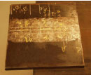 The photo shows a plan view of laboratory specimen S135 with the weld oriented horizontally. The specimen is comprised of a thicker plate to the top and a thinner plate to the bottom of the photo.