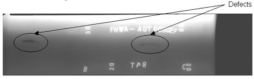 The radiographic image shows two longitudinal discontinuities. One discontinuity is located between markers A (not shown) and B while the other discontinuity is located between markers B and C. The discontinuities are circled for illustrative purposes.