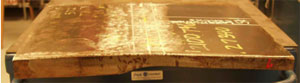 The photo shows a side view of laboratory specimen S136 with the weld oriented vertically. The specimen is comprised of a thicker plate on the left and a thinner plate on the right.