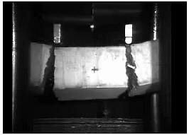 Figure 50. Photo. Six of eight plain concrete specimens initially failed with two major cracks in the impact regime. This is a snapshot from a video of a test showing the damage in the loading regime of one beam. The damage is two major cracks, one each beneath each impactor.