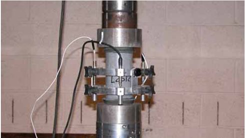 Short-term creep test setup. This photo shows the test setup for the application of a sustained compressive load onto a 76-millimeter diameter cylinder. The same parallel ring device that was used to measure the axial compression of cylinders during the A S T M C469 tests was used again here.