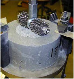 This photo shows the cutting head from the A S T M C944 abrasion test bearing on the surface of a U H P C cylinder.
