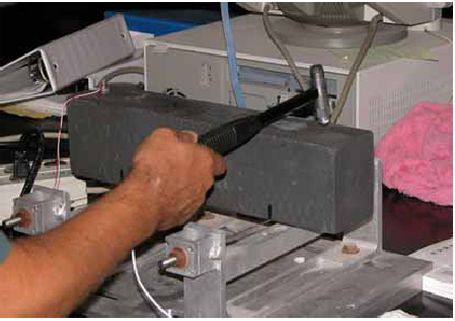 This photo depicts the use of the instrumented hammer to impart a vibration into a freeze/thaw prism.