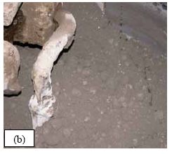 This series of five photos graphically depicts the stages in the mixing of U H P C as observed for all of the batches of concrete cast for this study. (a) shows the dry constituent materials in the pan mixer as the water is being added. (b) shows the U H P C in the mixer as the H R W A is added. (c) shows the U H P C before its conversion into a viscous paste. (d) shows the U H P C at the time of fiber addition. (e) shows the U H P C after mixing is complete.