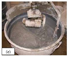 This series of five photos graphically depicts the stages in the mixing of U H P C as observed for all of the batches of concrete cast for this study. (a) shows the dry constituent materials in the pan mixer as the water is being added. (b) shows the U H P C in the mixer as the H R W A is added. (c) shows the U H P C before its conversion into a viscous paste. (d) shows the U H P C at the time of fiber addition. (e) shows the U H P C after mixing is complete.