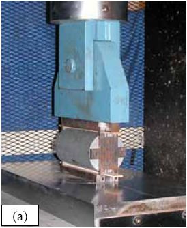 Photos. Split-cylinder tensile test including (a) standard test setup, (b) lateral expansion measuring apparatus, and (c) U H P C cylinder during test. (a) shows the placement of the cylinder into the testing machine. (b) shows the lateral displacement measurement device. (c) shows the testing of the cylinder with the lateral displacement being measured.