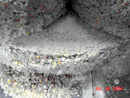 Figure 196. Photo. Typical cracking and spalling from freeze-thaw damage from test 1. The SRW unit shows cracking at the top edge of the unit.