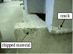 Figure 61. Photo. Defects along edges of SRW units. The picture is of SRW units. One unit has an arrow pointing to a crack on an SRW unit, and another SRW unit has an arrow pointing to chipped material.