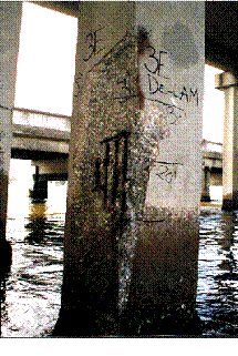 Figure 1. Photo. A cracked and spalled marine bridge piling. A photograph of a cracked and spalled marine bridge piling.