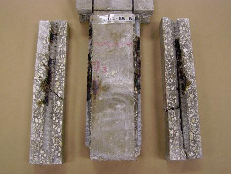 Figure 114. Photo. Specimen 3BTC-STD2-BB-B after sectioning and opening along the two longer bars. This is a photograph of specimen 3BTC-STD2-BB-B after sectioning and opening along the two longer bars. Corrosion is apparent on the bars and bar traces at mid specimen height.