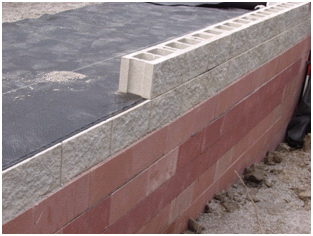 Figure 3. Photo. Split face CMU blocks. Photo showing split face concrete masonry unit (CMU) blocks on a geosynthetic reinforced soil (GRS) abutment being constructed. The photo shows an isometric view.