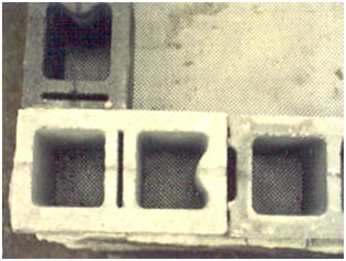 Figure 4. Photo. Detail view of split face CMU blocks. Photo showing split face concrete masonry unit (CMU) blocks on a geosynthetic reinforced soil (GRS) abutment being constructed. The photo shows a top-down view.