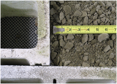Figure 5. Photo. Sample of VDOT 21-A gravel. Photo showing a sample of a VDOT 21-A well-graded gravel used in the construction of a geosynthetic reinforced soil (GRS) wall. A ruler is shown to give an idea of scale. The pieces are angular and of varying sizes, with the largest pieces about 0.5 inch by 1 inch.