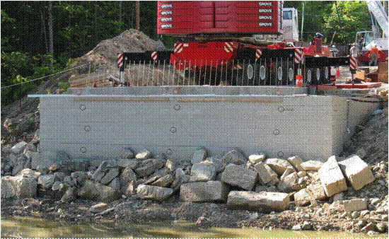 Photo showing the location of 12 survey targets located on the wall face and beam footing for the Tiffin River Bridge. There are three rows of four survey targets (one on the cast-in-place footing and three at the top, middle, and bottom of the exposed wall).