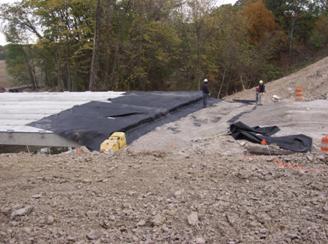 Figure 76 through figure 80 illustrate the process of forming the integrated approach by compacting layers of gravel directly against the ends of the beams. Each layer is wrapped with a sheet of geotextile. The propose of the wrapped layers is to prevent the migration of fill during thermal movement of the beams. The thickness of the each wrapped layer is about 12 inches. The 12-inch layer is compacted in 6-inch layers with small secondary sheets of reinforcement placed between each 6-inch layer at the beam ends.