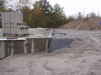 Photo showing a side view of the complete integrated approach. The top wrapped layer is nearly at the same height as the concrete bridge beam.