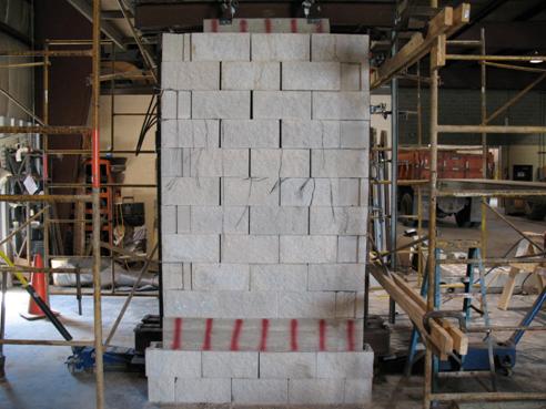 Photo showing the Defiance County experiment after loading. The geosynthetic reinforced soil (GRS) mass is bulged, and the joint between blocks has increased near the top middle, but the blocks are still stable.