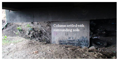 Photo. Column settlement under approach to Juan Pablo II bridge (cracks on far side). Click here for more information.