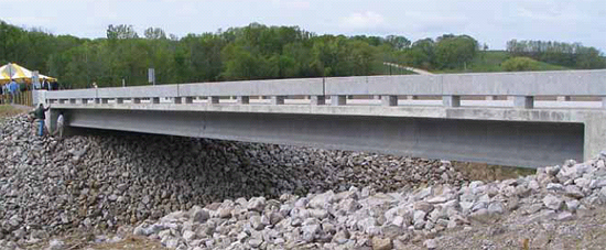 This photo shows the first ultra-high performance concrete (UHPC) bridge constructed in the United States. The bridge includes three UHPC prestressed I-girders spanning a creek in rural Iowa.