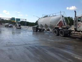 This photo shows the equipment used to profile the surface of a bridge deck after re-decking with precast concrete deck panels and field-cast ultra-high performance concrete connections. The equipment is profiling a partial lane width at a time.