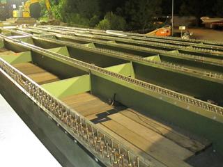 This photo shows the superstructure of a steel girder bridge during deck reconstruction. The deck has been removed, the new shear studs have been installed, and the haunch formwork is in place.