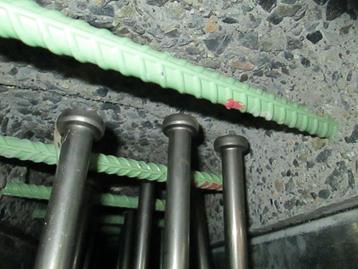 This photo shows the hidden pocket composite connection detail with tall studs extending above the bottom mat of reinforcing bars. The exposed aggregate surface on the concrete is visible. This connection detail could be used with conventional grout, concrete,  ultra-high performance concrete.