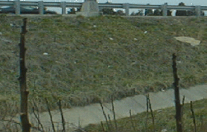 Concrete-lined drainage channel leading to a nearby drainage basin.