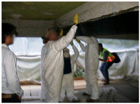 This photo shows five people installing fiber-reinforced polymer (FRP) wrap underneath a bridge.