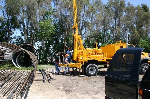 This photo shows a drill rig used to install access tubes in the ground around the proposed location of the voided shaft, which was to be constructed later. These access tubes in the soil were installed at various distances from the edge of the proposed shaft location several weeks prior to shaft construction.