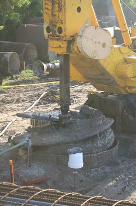 This photo shows the excavation of the shaft that was completed with a truck-back drill rig equipped with a 9-ft (2.75-m)-diameter auger and surface casing to support the upper soils. Around the surface casing, the access tubes previously installed were painted flourencent orange to minimize inadvertent disturbances.