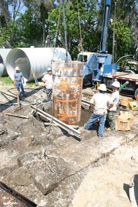 This photo shows the placement of the central casing into the voided shaft. The inner face of the voided shaft was formed by the central casing installed in the excavation after the cage. The weight of the casing was sufficient to cut into the soil at the bottom of the excavation approximately by 6 inches (152.4 mm) as indicated by the lengths premarked on the side of the casing.