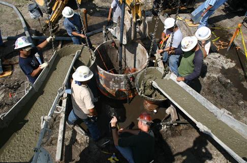 This photo shows the pouring of the concrete around the central casing. Two tremies were placed at roughly opposite sides of the annular region formed between the cage and the central casing. This allowed two concrete trucks to supply two sources of concrete.