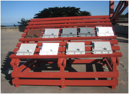 The photo shows type II panels at the Golden Gate Bridge (GGB) in San Francisco, CA. There is a wooden rack, which is inclined 30 degrees facing south. The rack contains wooden runner panels installed on the frame of the rack in order to support the type II panels.