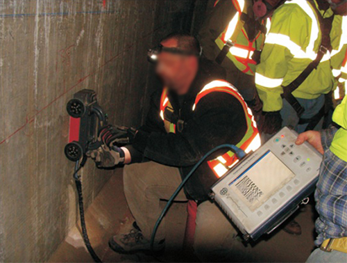 Figure 64. Photo. Locating internal tendons in the web wall using GPR. This photo shows a worker using ground penetrating radar (GPR) to locate an internal tendon within a web wall.