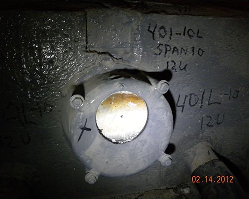 Figure 65. Photo. Partial removal of a grout cap. This photo shows an end cap of an internal tendon after partial removal of the cap by coring. Sound, new exposed grout is seen where the end cap was cored.
