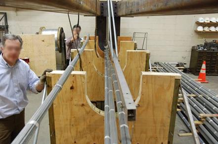 This photo shows the beginning of the assemblage of the strands starting from the lower ones. Workers standing next to the stands are making sure that they are aligned properly. 