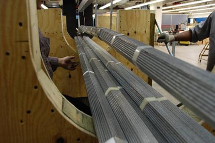 This photo shows the assemblage of a strand along the central axis of the cable cross section. A worker next to the strand is checking that the strand is placed in the proper location without overlapping with the neighboring strands. 