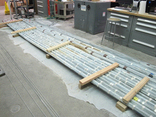This photo shows removed cable strands lined up on the ground. Cable strands removed from the cable were restructured into hexagonal shape (kept intact with fiber-reinforced tape) and placed in lines based on their previous location within the cable.