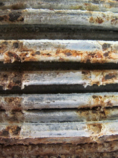 This photo shows pitting corrosion under the stainless steel strap. The salt deposit was cleaned from the wire surface to reveal pitting corrosion. Ferrous oxide is seen at points where the straps contacted the cable wires.
