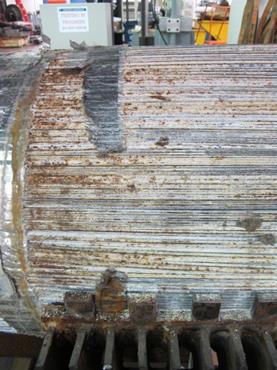 This photo shows the south end of the cable without the upper part of the cable band. The top portion of the jacking endâ€™s cable band has been removed. Stage 2 and stage 3 corrosion are shown on the wires from the surface of the cable. Duct tape used to keep the free wires in place during construction is shown to be extremely worn. Stage 3 ferrous corrosion is more prevalent closer to the end of the cable. 