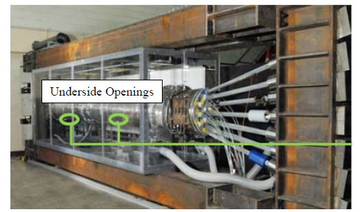 This photo shows a mockup cable specimen within an environmental chamber. Green circles are present to highlight the location of two holes placed in the aluminum cable cover. The holes are located on the bottom side of the cable. The total cable and the loading frame are shown with the jacking ends to the right side of the image. 