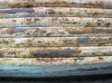This photo shows a close-up view of the strand adjacent to the pre-corroded strand. The adjacent side with an area of approximately 2.5 by 2.5 inches (63.5 by 63.5 mm) shows stage 3 corrosion. 