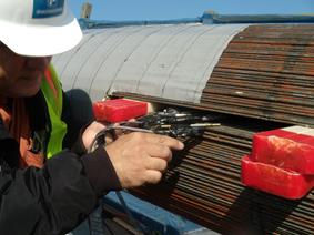 This photo shows a person decommissioning the monitoring system by wedging the cable and pulling the sensors out. 