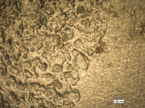 This figure shows the A710 steel surface observed under visible light with an optical microscope before the doping and extraction process. The scale bar in the image is 0.04 inches (1 millimeter) long.