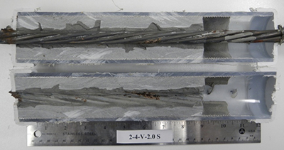 Figure 198. Photo. Stressed single-strand specimen with void and 2.0 percent chloride. This photo shows the as-extracted condition of a 2.0 percent chloride stressed single-strand specimen with void. Significant corrosion is visible.