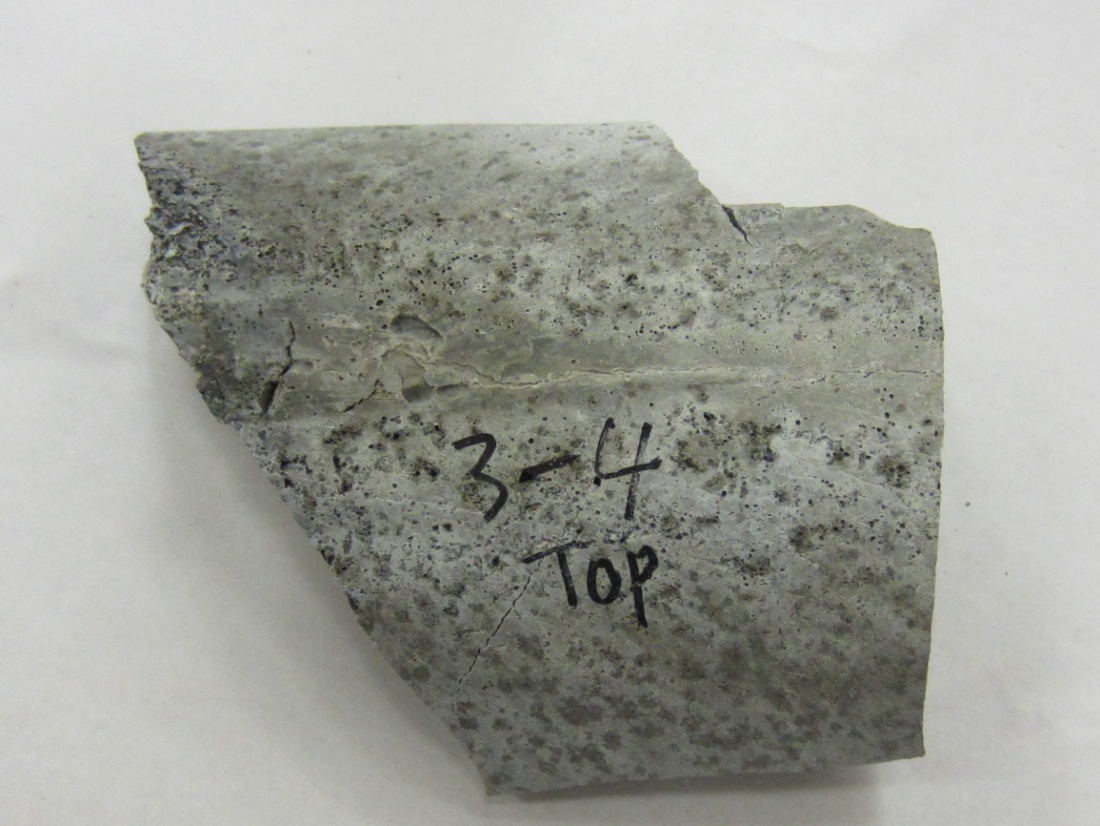 Figure 222. Photo. Top side grout piece exhibiting bleed channel and porous grout   removed from 0.4 percent chloride specimen. This photo shows a grout piece taken from near the interface of 0.4 percent chloride multi-strand specimen. A bleed channel and poor grout condition are visible.