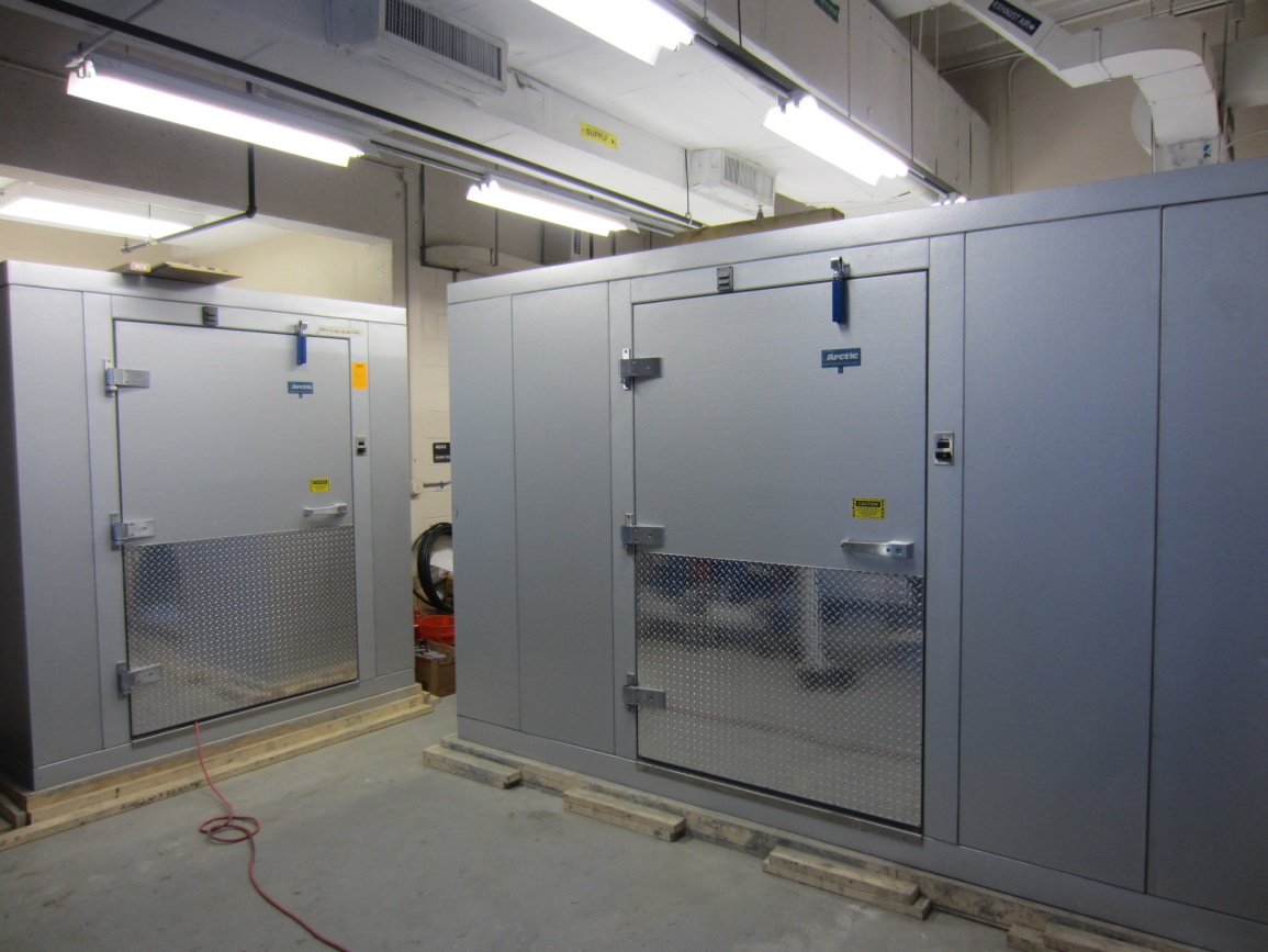 Figure 3. Photo. Environmental chambers. This photo shows an exterior view of a smaller environmental chamber on the left and a larger environmental chamber on the right inside 
a laboratory. 