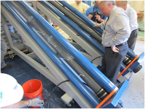 Figure 39. Photo. Grout pumping into a multi-strand specimen. This photo shows grout being pumped into a clear polyvinyl chloride tube of a multi-strand specimen.