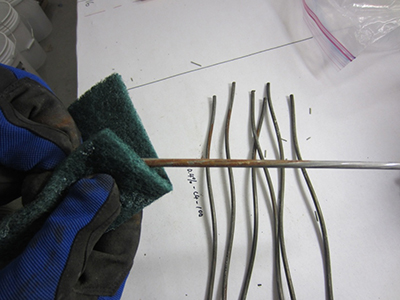 Figure 64. Photo. Cleaning individual wires using a scrubbing pad. This photo shows the first step of cleaning corroded wires using a scrubbing pad.