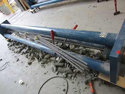 Figure 72. Photo. Extracting a multi-strand bundle from a loading frame. This photo shows the cut strands being taken out of the loading frame